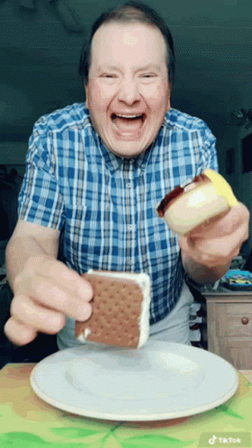Man in Plaid Shirt Eating Ice Cream Sandwich on White Plate