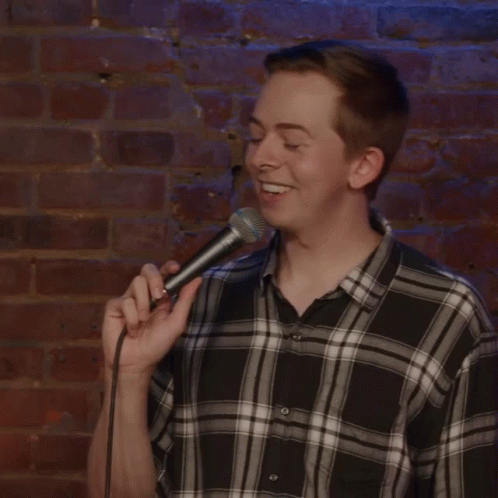 Man in Plaid Shirt Holding Microphone