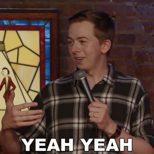 Man in Plaid Shirt Holding Microphone Saying Yeah Yeah