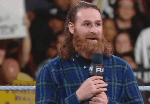 Man in Plaid Shirt Holding Microphone With NFM