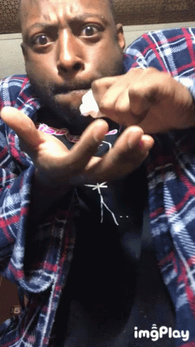 Man in Plaid Shirt Holding Something