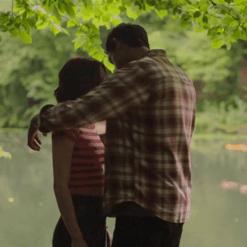 Man In Plaid Shirt Hugging Woman In Red Striped Top GIF
