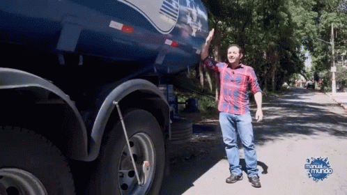 Man in Plaid Shirt in Front of Blue Truck Manual Do Mundo
