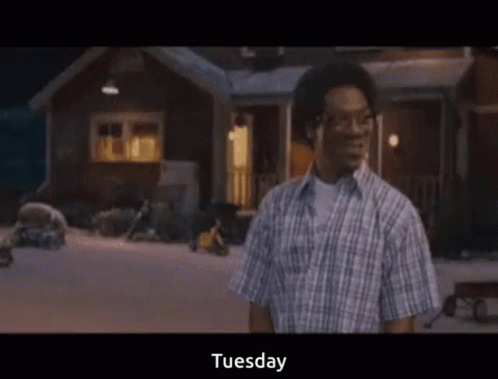 Man in Plaid Shirt in Front of House