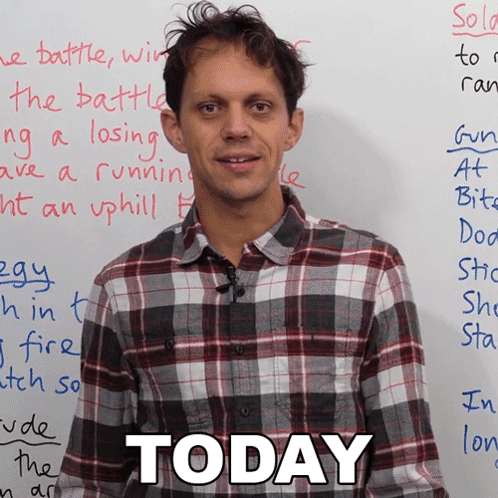 Man in Plaid Shirt in Front of White Board That Says Today