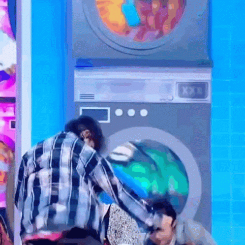 Man in Plaid Shirt Next to Washing Machines