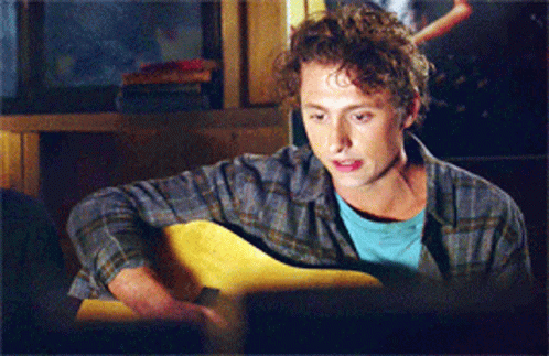 Man in Plaid Shirt Playing Guitar