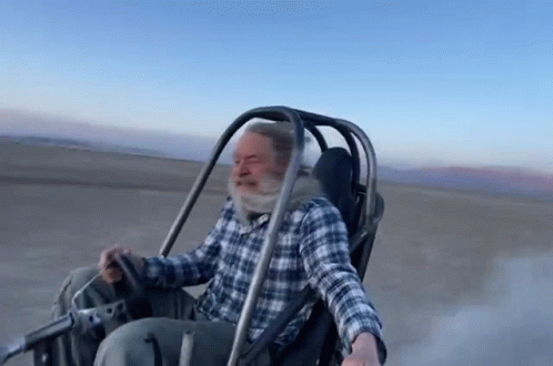 Man in Plaid Shirt Riding Buggy on Dirt Road