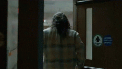 Man in Plaid Shirt Running Through Doorway