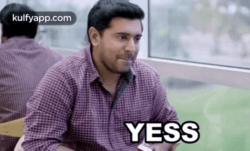Man in Plaid Shirt Saying Yes at Table
