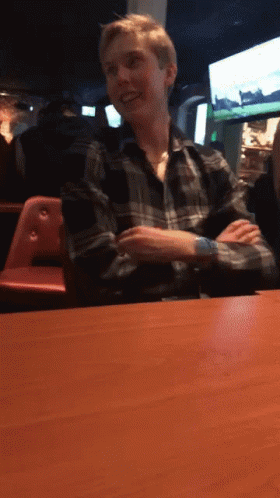 Man In Plaid Shirt Sitting At Table GIF