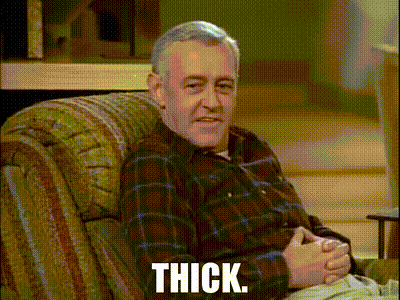 Man in Plaid Shirt Sitting in Chair Thick