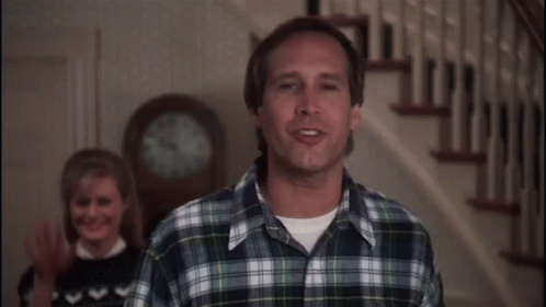 Man in Plaid Shirt Standing in Front of Clock