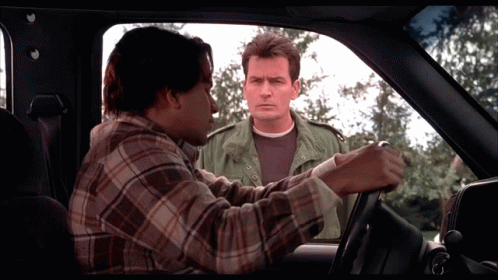 Man in Plaid Shirt Talking to Another Man in Car