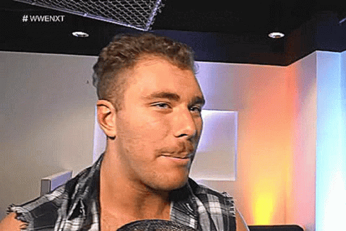 Man in Plaid Shirt With Microphone in Mouth