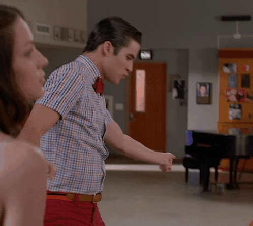 Man in Plaid Shirt with Red Bow Tie Pointing