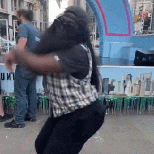 Man in Plaid Vest Dancing by Unit Sign