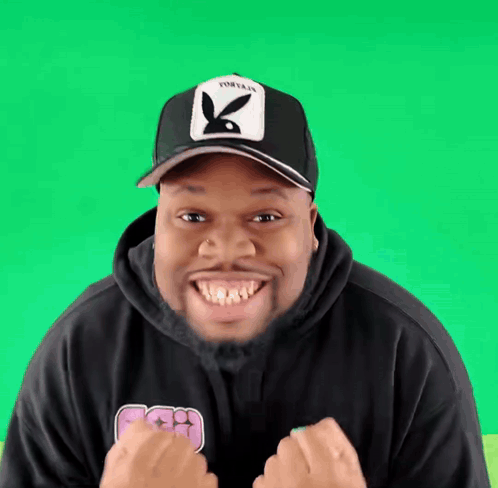 Man In Playboy Hat And Black Hoodie Smiling GIF