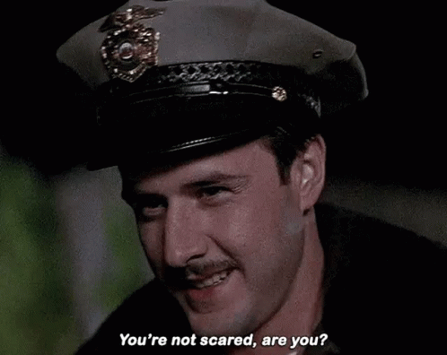 Man in Police Hat Asking If Not Scared