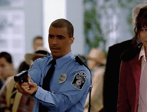 Man in Police Uniform Pointing Gun at Woman