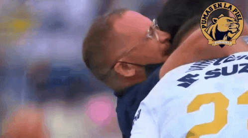 Man in Pumas Jersey Kissing Another