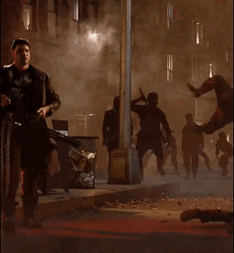 Man In Punisher Costume Holding Machine Gun GIF