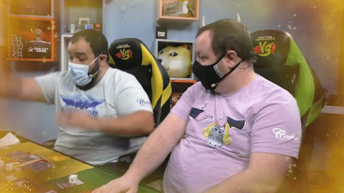 Man in Purple Cat Shirt Next to Masked Man