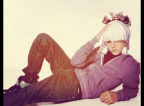 Man In Purple Hoodie And White Hat Lying GIF