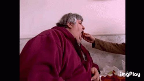 Man in Purple Jacket Eating from Hand
