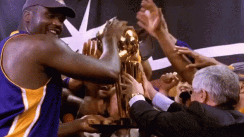 Man in Purple Jersey Holding Gold Trophy
