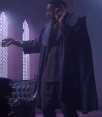 Man In Purple Robe In Front Of Couch GIF