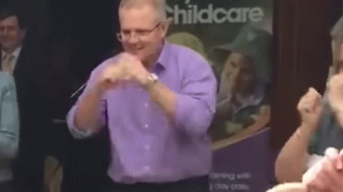 Man in Purple Shirt and Glasses Dancing at Childcare Sign