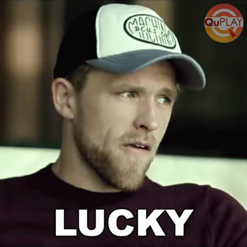 Man in Purple Shirt and Hat Saying Lucky