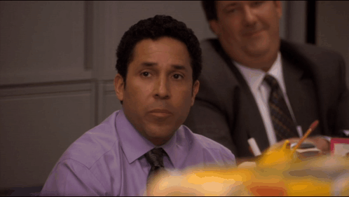 Man in Purple Shirt and Tie at Table