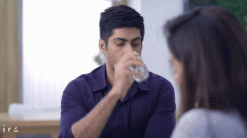 Man in Purple Shirt Drinking From Glass