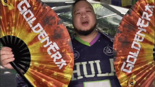Man In Purple Shirt Holding Goldenera Fan GIF