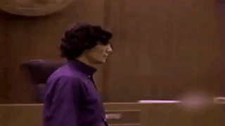 Man In Purple Shirt In Dark Room GIF