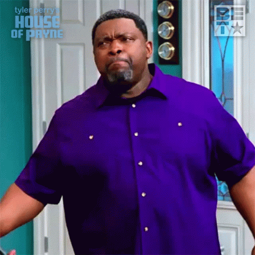 Man in Purple Shirt Making Face in Front of Door