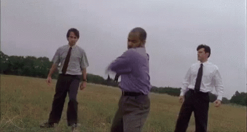 Man in Purple Shirt With Two Others in Field