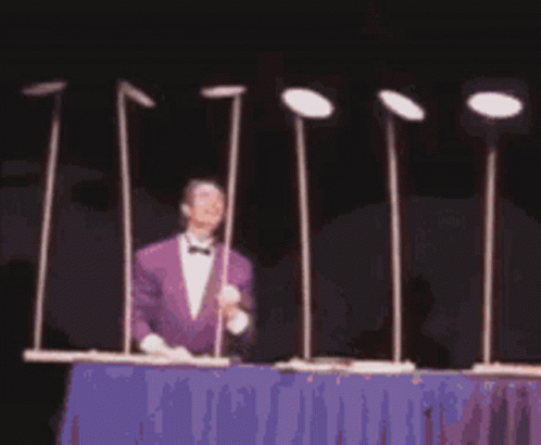 Man in Purple Suit Beside Metal Poles with Plates