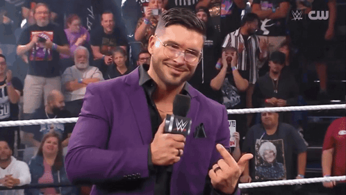 Man In Purple Suit Holding Microphone GIF