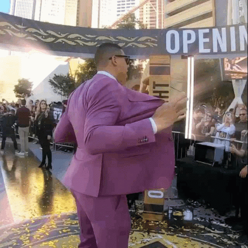 Man in Purple Suit in Front of Open Sign