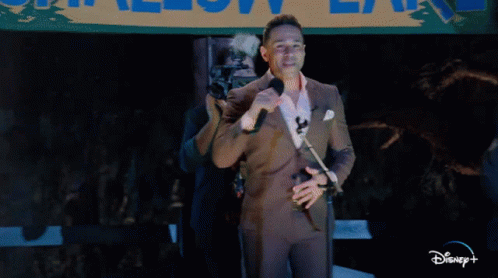 Man in Purple Suit Singing Into Microphone Allow Lane