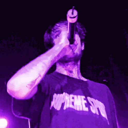 Man in Purple Supreme Shirt Singing into Microphone