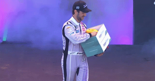 Man in Racing Suit Holding Foodie Box