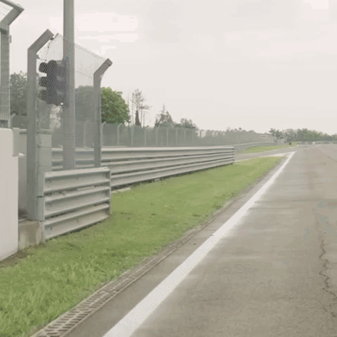 Man in Racing Suit Walking Down Race Track