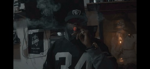 Man in Raiders Hat Smoking