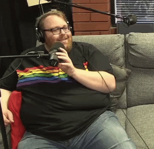 Man in Rainbow Shirt Talking Into Microphone