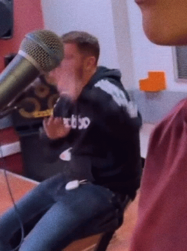 Man in RBSO Hoodie Talking Into Microphone