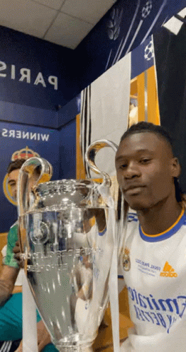 Man in Real Madrid Jersey Holding Trophy